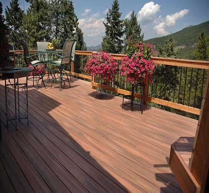 A deck and back yard overlooking a mountain
